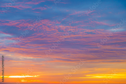 Dramatic, vibrant sunrise, sunset sky, cloudscape in a mixture of golden, orange, pink and blue colours. 