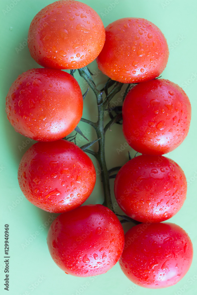 red tomatoes with green leaves. Top view. Green background. red tomatoes with green leaves. Top view. Green background.