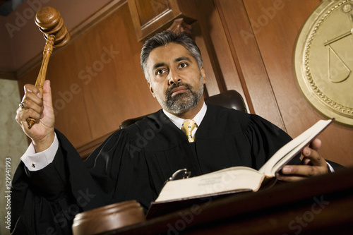 Fototapeta Male judge knocking gavel in the courtroom