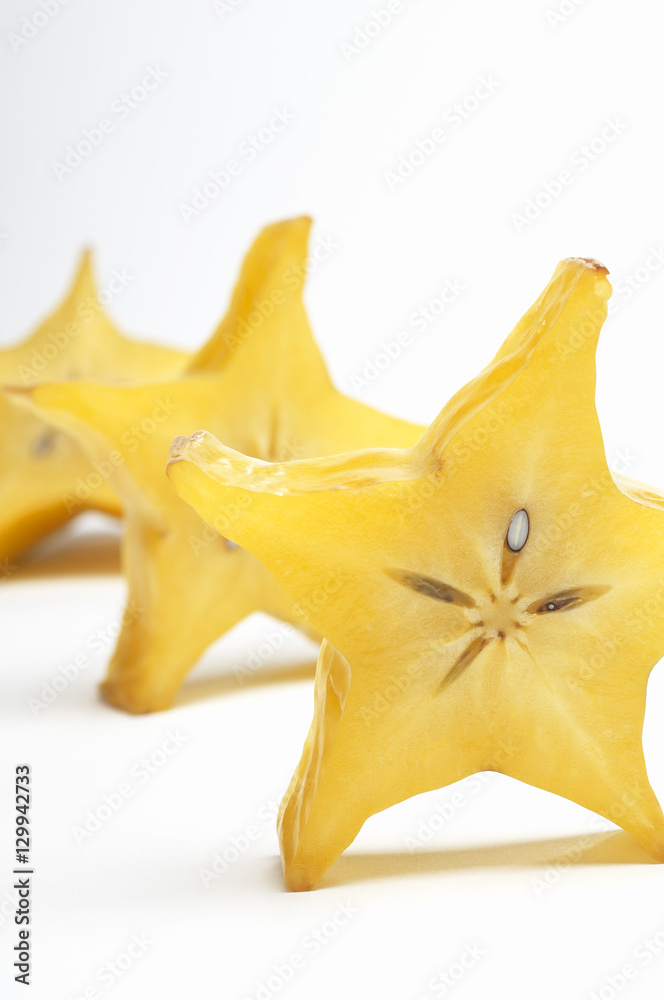 Closeup of sliced starfruit in a row isolated over white background Closeup of sliced starfruit in a row isolated over white background