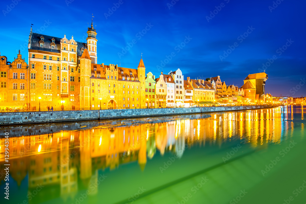 Night view on the illuminated riverside with beautiful buildings of the old town in Gdansk, Poland
