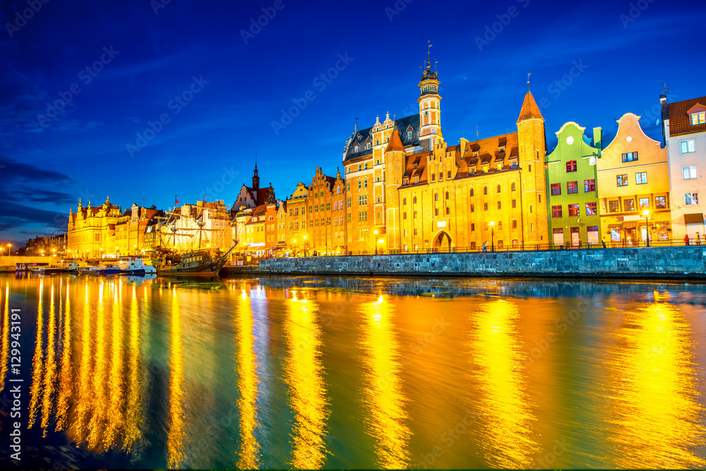 Night view on the illuminated riverside with beautiful buildings of the old town in Gdansk, Poland