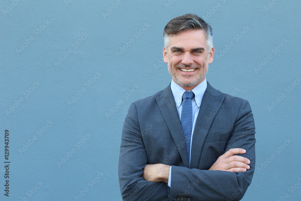Mature handsome Caucasian businessman smiling with arms crossed Mature handsome Caucasian businessman smiling with arms crossed