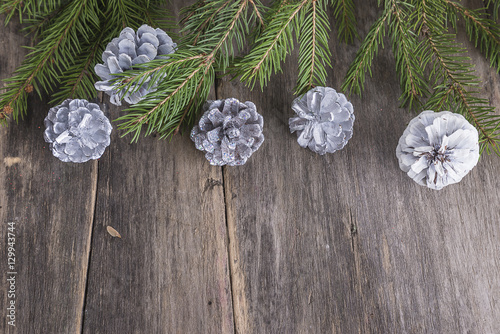 Fir branches with white cones on old wooden background with space