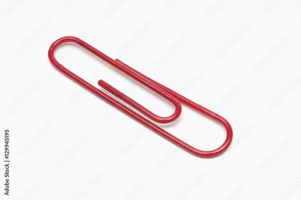 Closeup of red paperclip over white background Closeup of red paperclip over white background