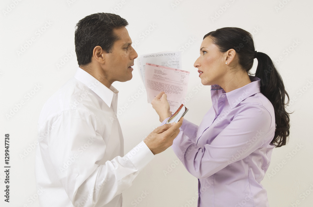 Side view of couple arguing over expenses against white background Side view of couple arguing over expenses against white background