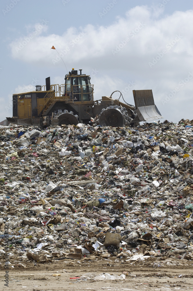An Excavator moving trash at dumping ground An Excavator moving trash at dumping ground