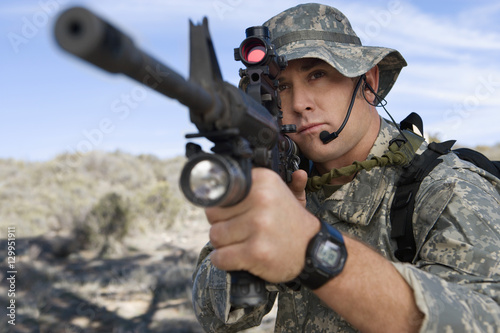 US army soldier on mission aiming machine gun