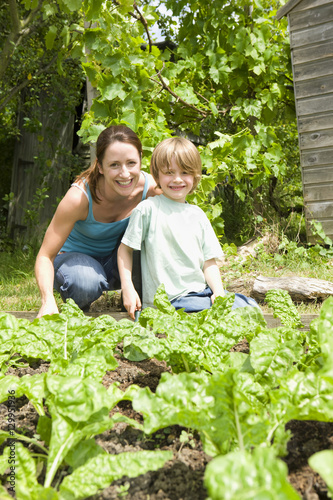 Portrait of happy mother and son gardening together in an allotment