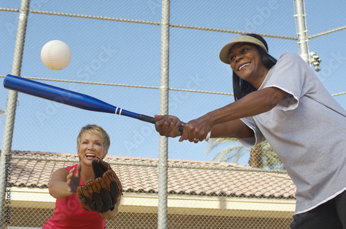 Photography Two happy multiethnic female friends playing baseball