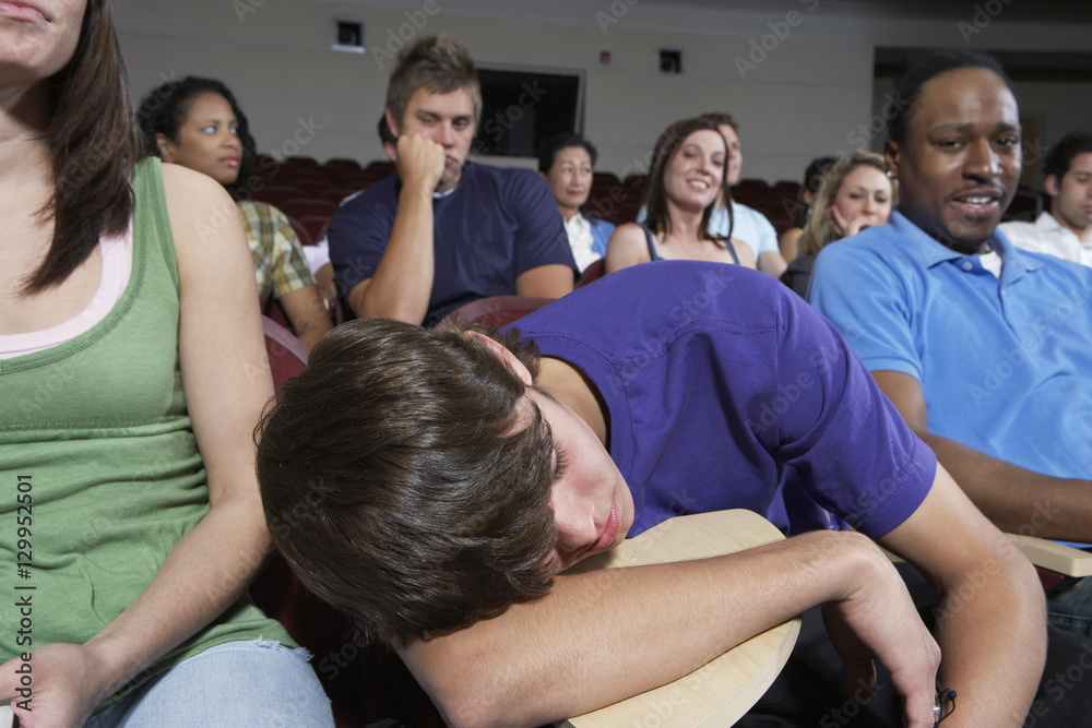 Bored students in lecture theatre during lesson Bored students in lecture theatre during lesson