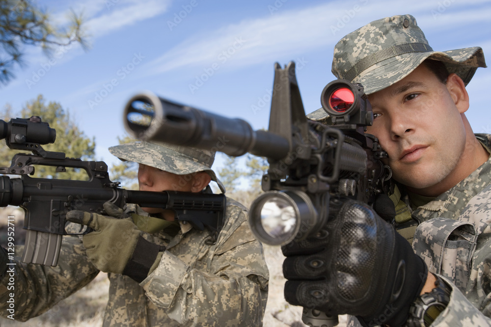 Fototapeta premium Two US army soldiers aiming with machine guns on a mission