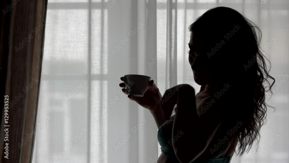 Woman with cup near window. Lady touching her hair. My morning starts from espresso. Feel lightness and energy.