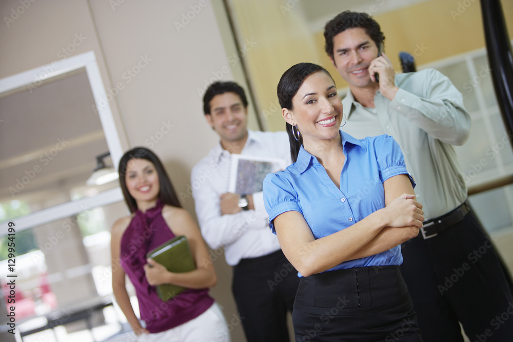 Portrait of a happy businesswoman with colleagues in the background Portrait of a happy businesswoman with colleagues in the background
