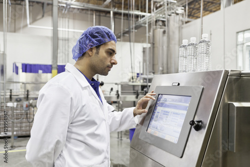 Tableau sur toile Industrial worker at bottling machine