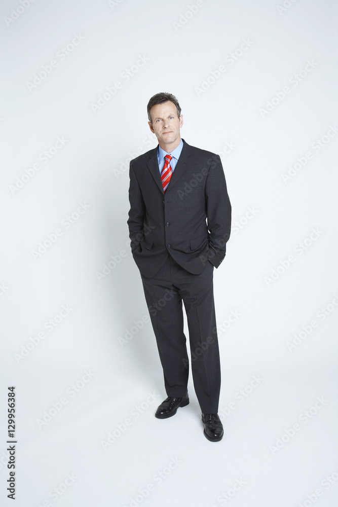 Portrait of a confident businessman with hands in pockets standing over white background Portrait of a confident businessman with hands in pockets standing over white background