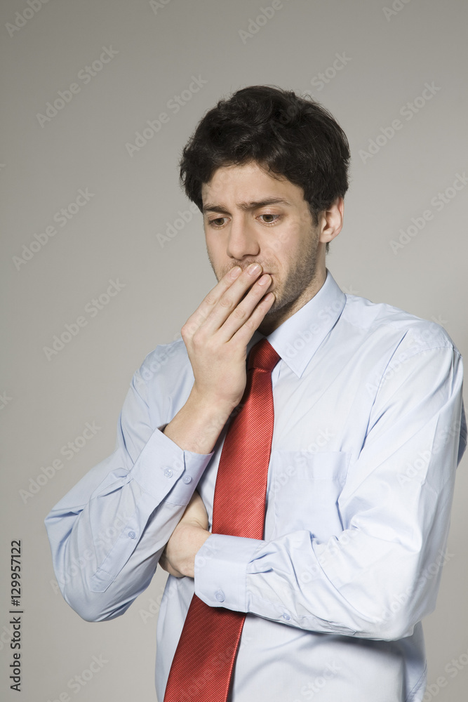 Thoughtful young businessman isolated over grey background Thoughtful young businessman isolated over grey background
