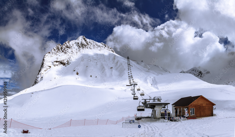 Covered with snow Aibga mountain peak ski slopes and chair ski lift winter mountain wide angle scenery
