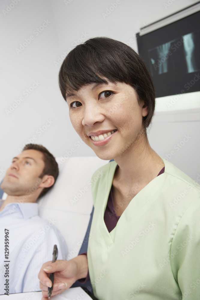 Portrait of a happy nurse with man lying on bed in the clinic Portrait of a happy nurse with man lying on bed in the clinic