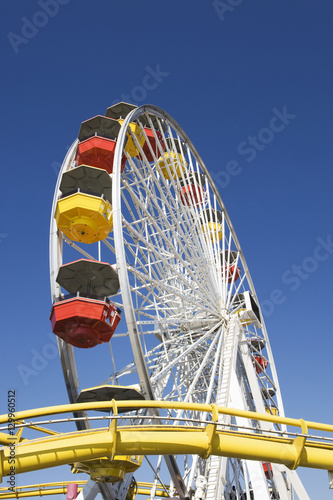 Low angle view of colorful Ferris wheel in amusement park against blue sky, California, USA