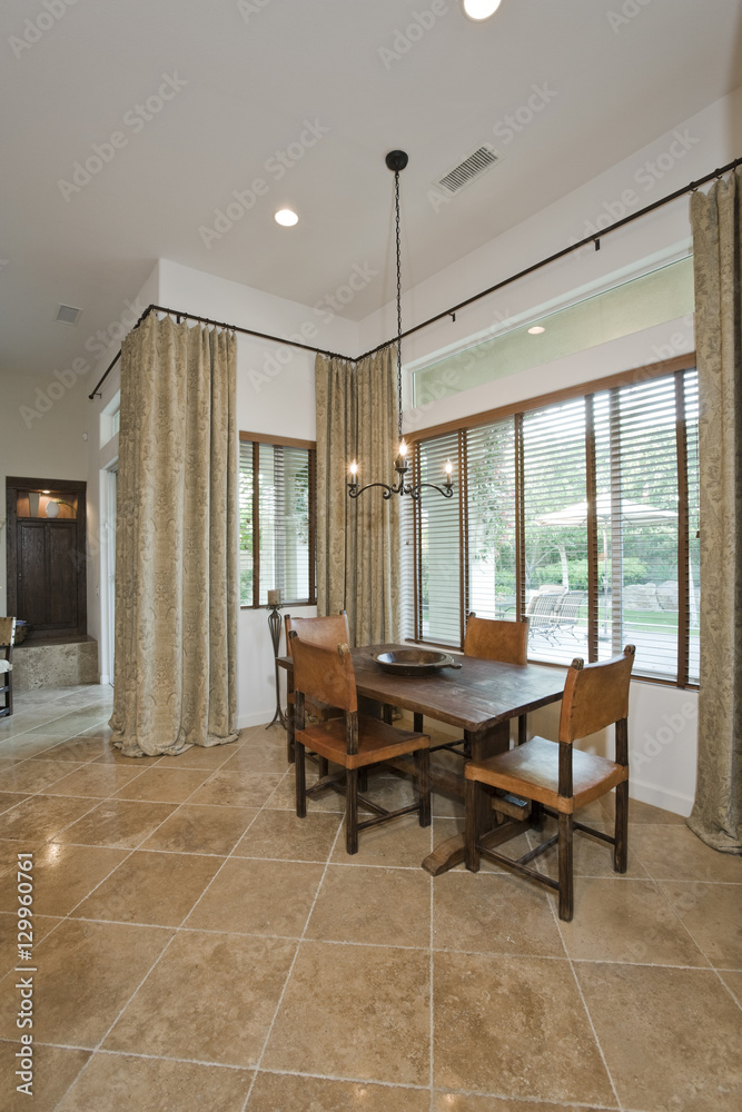 Four chairs with dining table on tiled floor in modern house