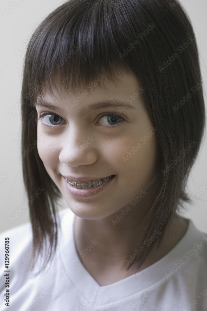 Closeup portrait of a smiling young girl with brown hair against colored background Closeup portrait of a smiling young girl with brown hair against colored background