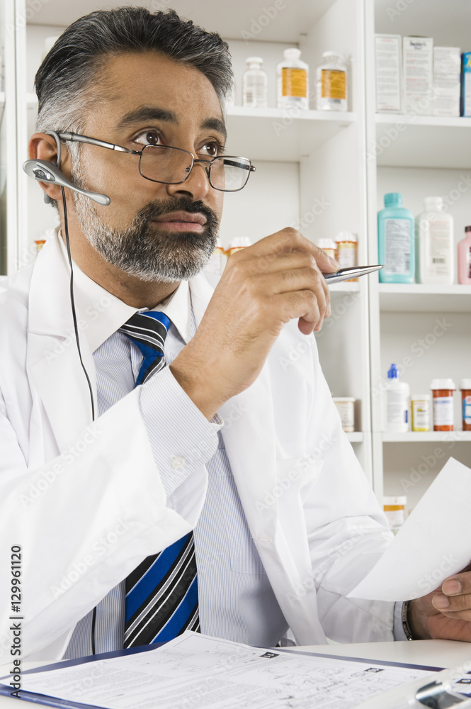 Middle aged Indian male pharmacist working in pharmacy