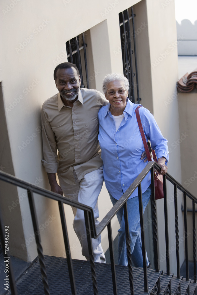 Portrait of happy African American mature couple climbing stairs