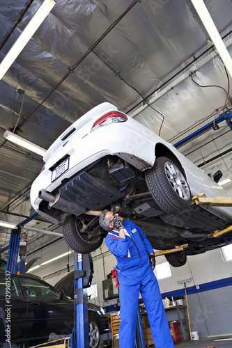 Technician working on car at automobile repair shop