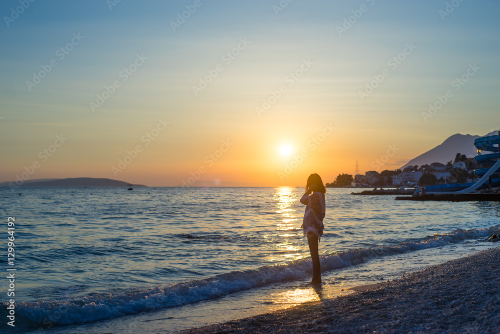 young woman on the beach at sunset