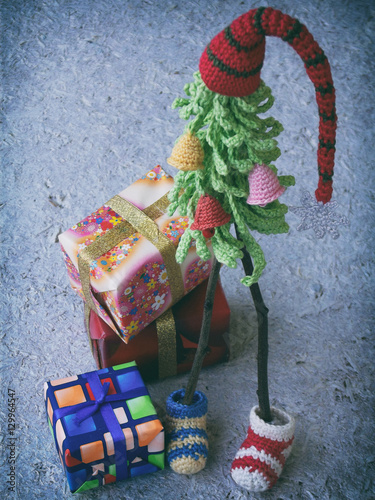 Creative Crochet Christmas trees with gifts on wooden background. New Year and Xmas card background. Copy space. Selective focus. photo