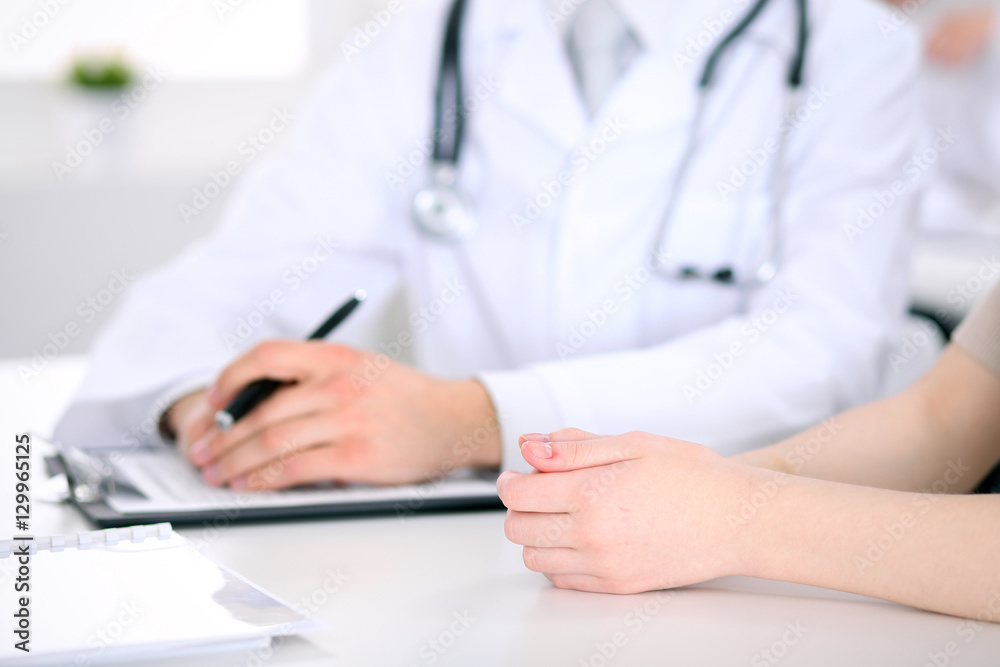 Doctor and patient are discussing something, just hands at the table Doctor and patient are discussing something, just hands at the table