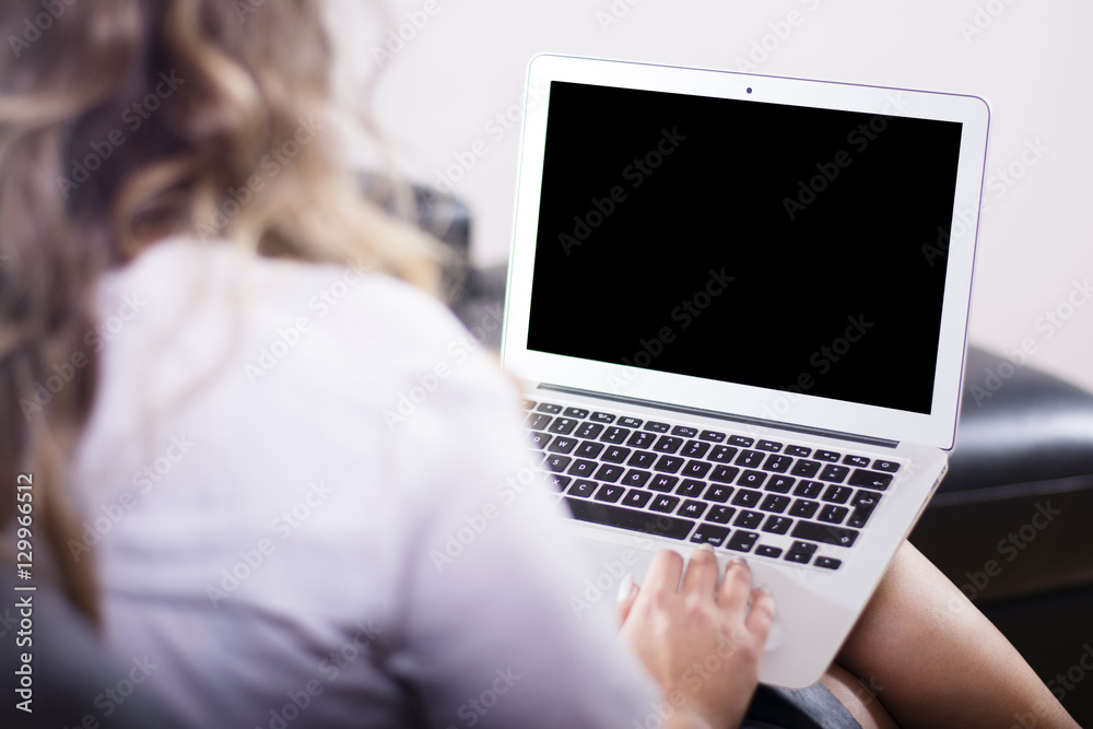 Woman sitting on a sofa using a laptop at home. Woman sitting on a sofa using a laptop at home.