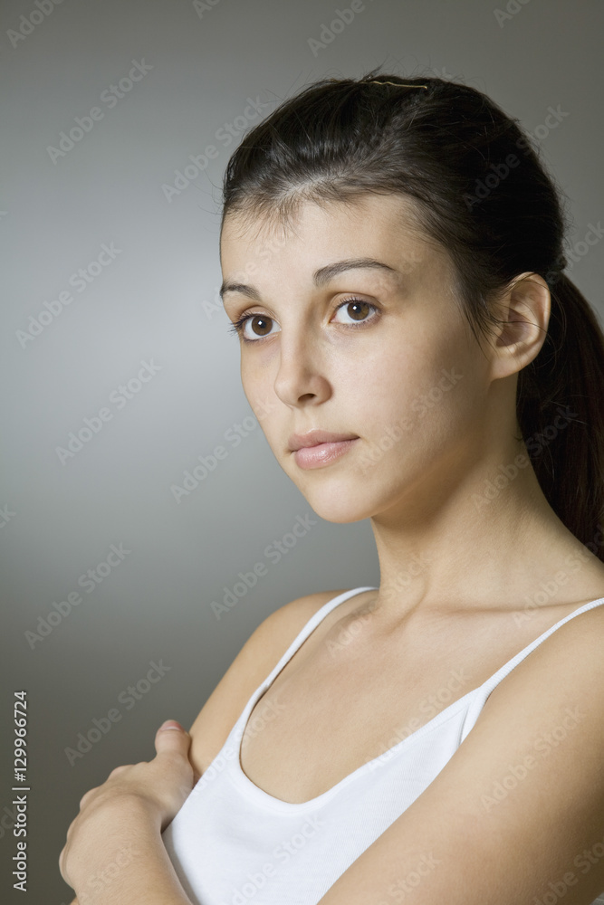 Closeup of a beautiful young woman against gray background Closeup of a beautiful young woman against gray background