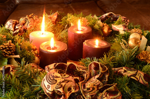 Traditional Advent wreath on rustic table with candles glowing warm