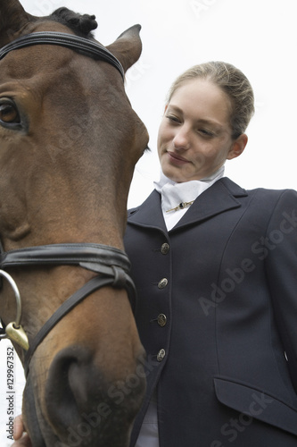 Closeup of a young female horseback rider with horse