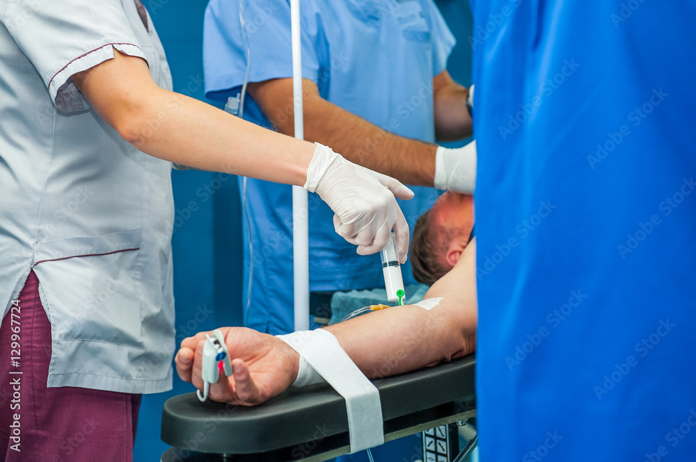 Close up anesthesiologist inserts the syringe making anesthesia to a patient Close up anesthesiologist inserts the syringe making anesthesia to a patient