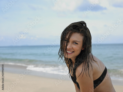 Fotografie Portrait of a happy young woman in bikini at the beach