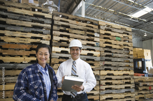 Portrait of a smiling man and woman standing in distribution warehouse
