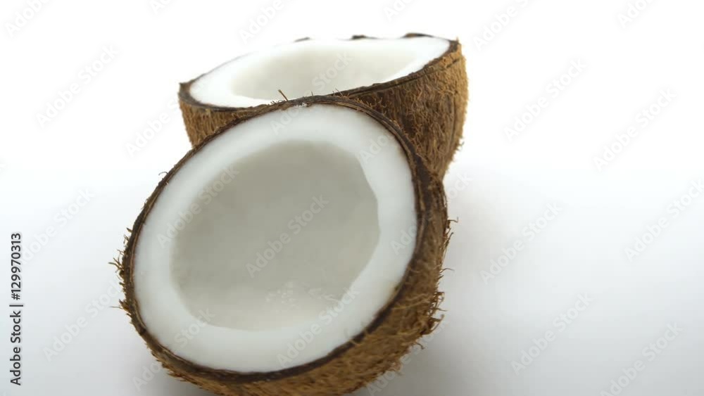 Ripe tropical coconut split in two halves rotating on white background. Looping exotic fruits. Ripe tropical coconut split in two halves rotating on white background. Looping exotic fruits.