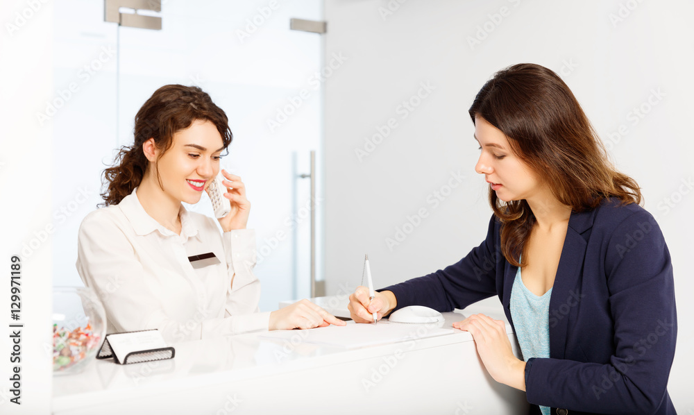 friendly woman behind reception desk administrator with customer friendly woman behind reception desk administrator with customer