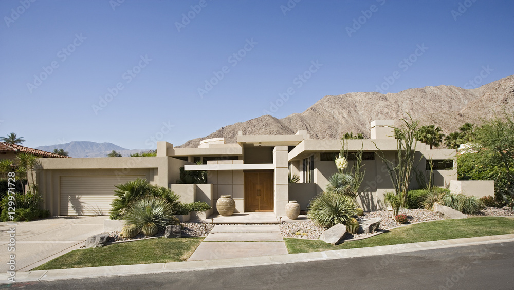 View of a modern suburban house exterior with road in foreground View of a modern suburban house exterior with road in foreground
