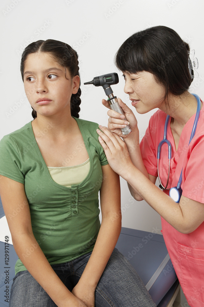 Female doctor checking teenage girl's ear with an otoscope Stock Photo ...