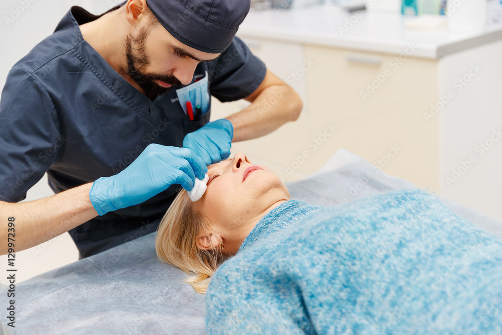 marking face of elderly woman old of plastic surgery at receptio