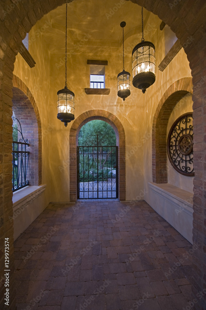 Arched hallway with lit hanging lights in modern home