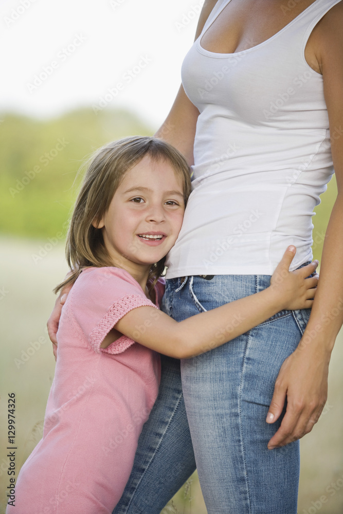 Portrait of a cute little girl hugging her mother in the field Portrait of a cute little girl hugging her mother in the field