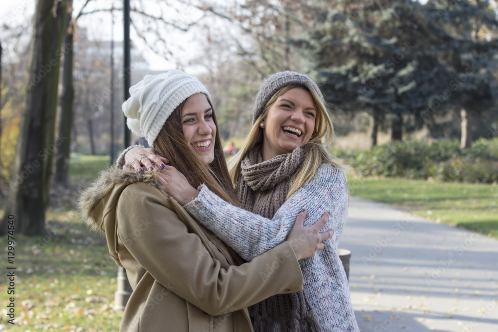 Two girls on park hug each other Two girls on park hug each other