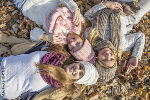 three girls laying on the ground in park