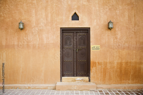 Canvas Print Closed door of Al Ain Palace Museum with lanterns on wall, Al Ain, Dubai, UAE
