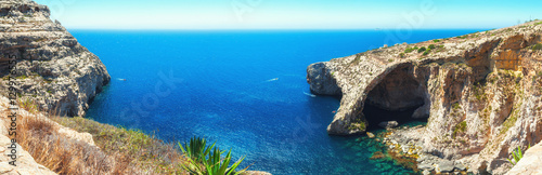 Famous Blue Grotto in Malta near Zurrieq on a calm sunny day. Horizontal panorama from 5 vertical frames.